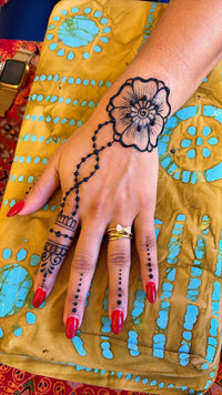 Hand with jagua design on a colorful fabric background